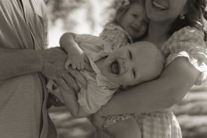 Candid black and white photo of a family sharing tender moments in nature.