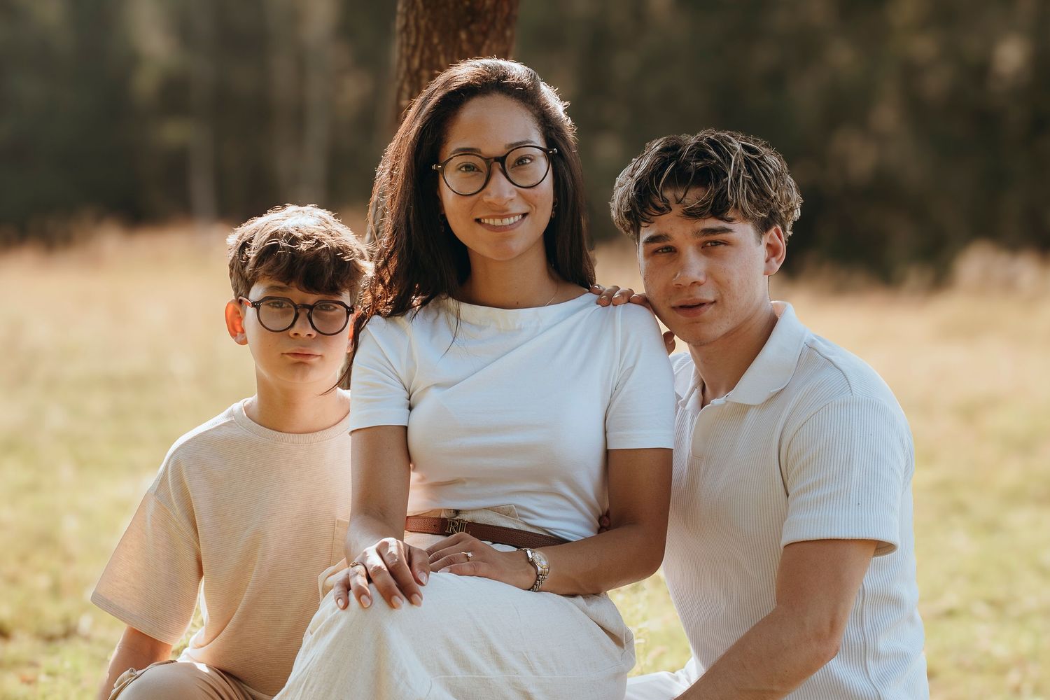 Happy family of four sharing loving moment together under tree branches.