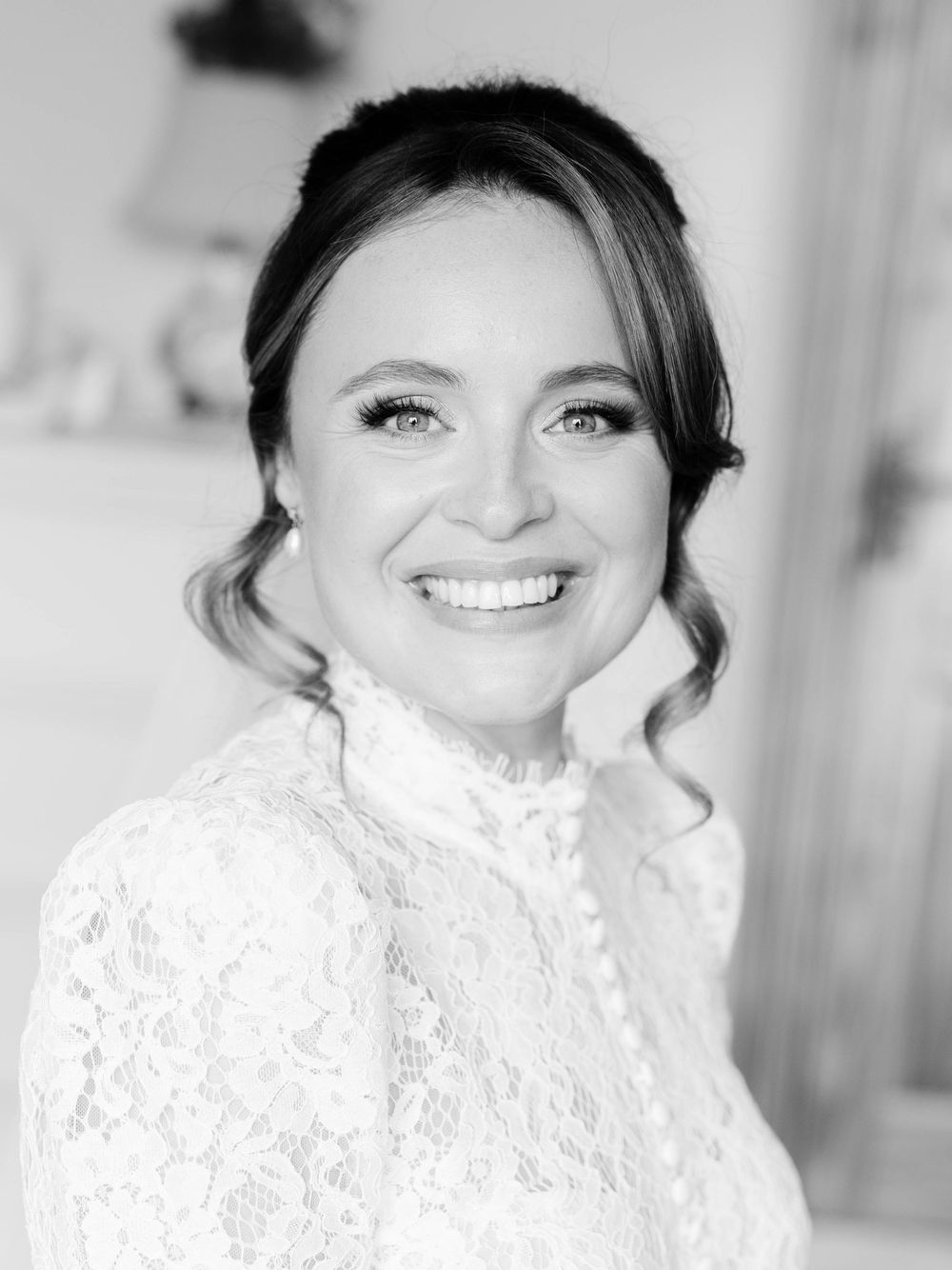 A radiant portrait in black and white showing an elegant lace dress with high neckline.