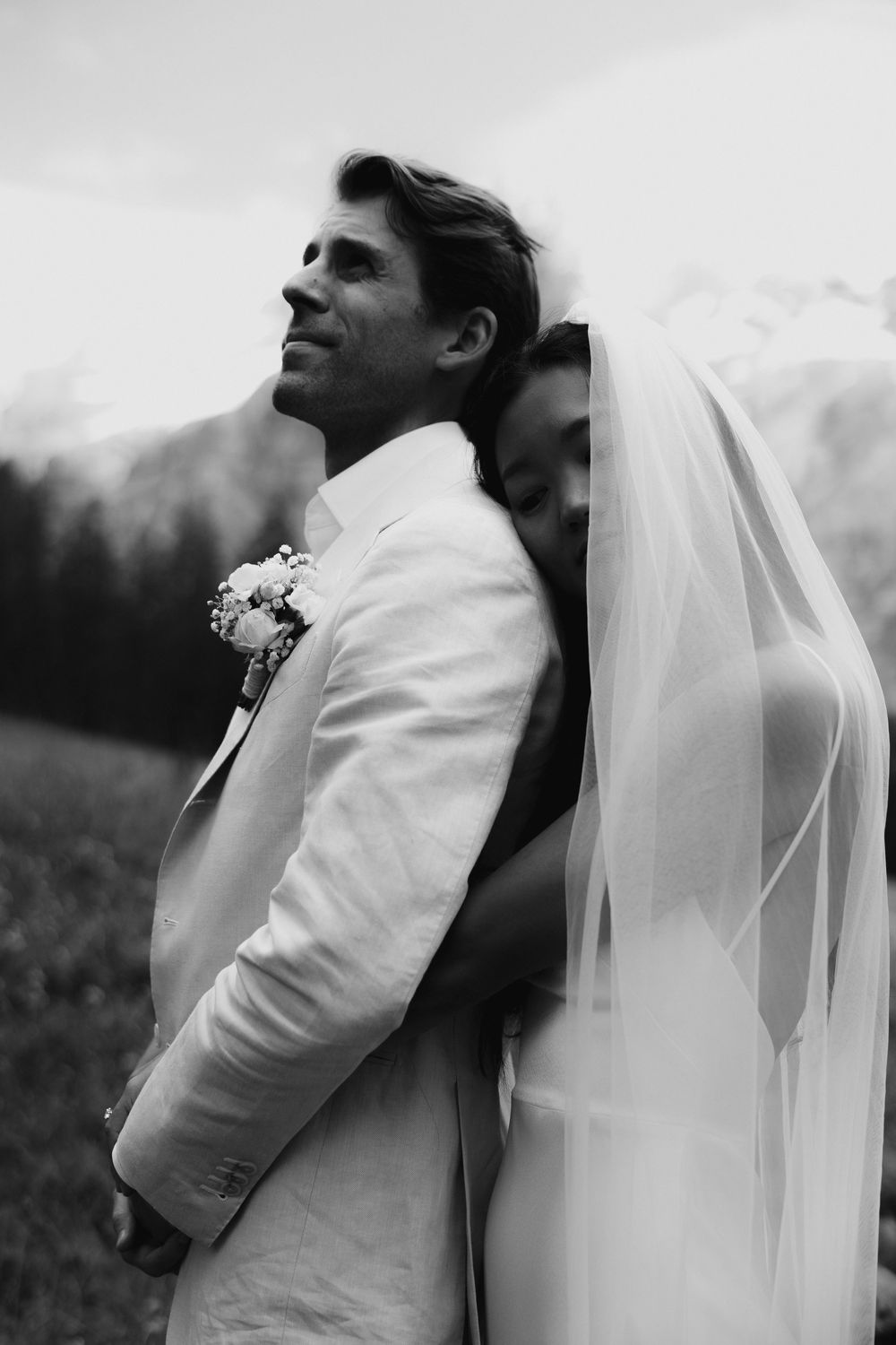Ethereal side profile portrait featuring flowing white veil against mountain scenery.