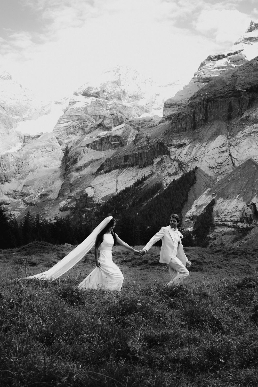 White flowing fabric dances in the wind against a majestic mountain backdrop.