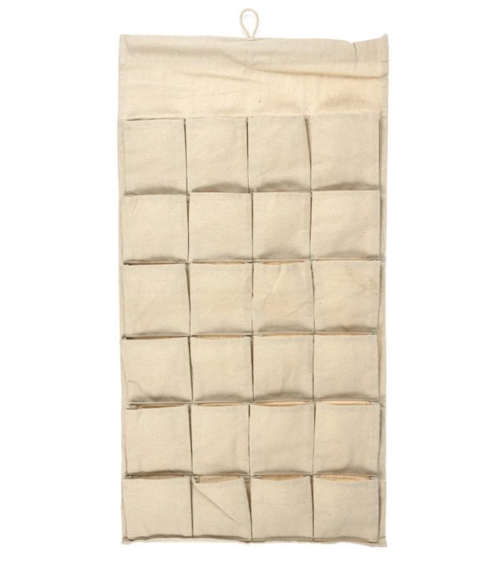 A beige hanging organizer with multiple pockets for storage made from canvas material.