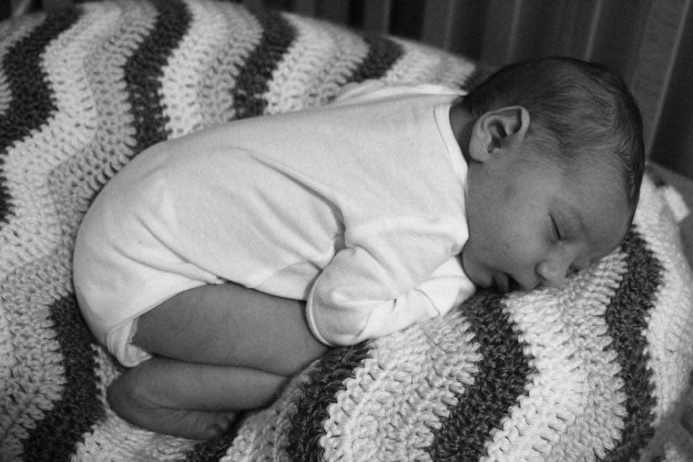 Image of a newborn sleeping on a blanket.