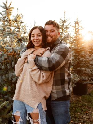 couple hugging in a christmas tree lot