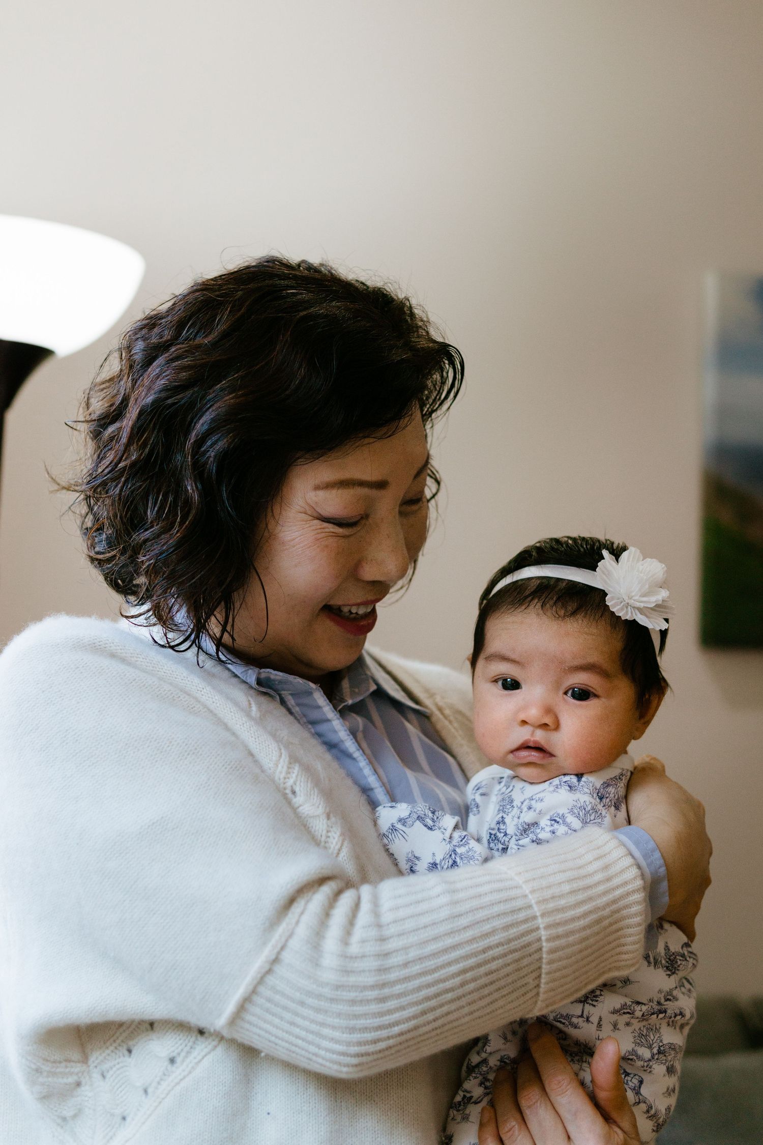 A tender moment of grandma smiling at newborn at an indoor newborn photoshoot in Philly.