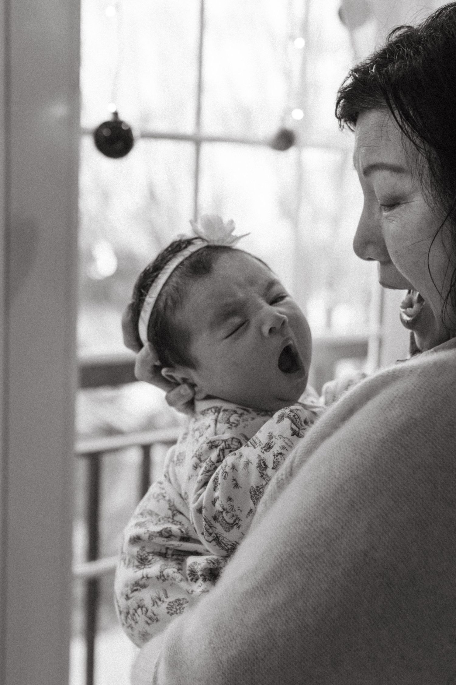 A tender black and white photograph captures a yawning baby and her grandmother's big reaction.