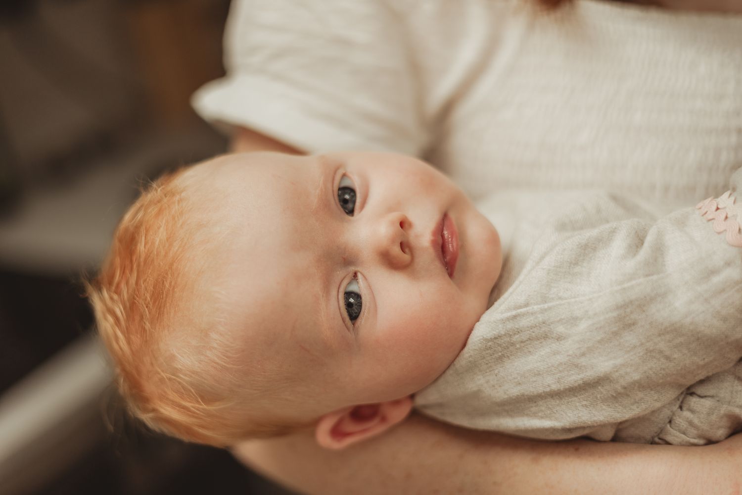 A series of connected photos showing a baby in white clothing looking at the camera from different angles.