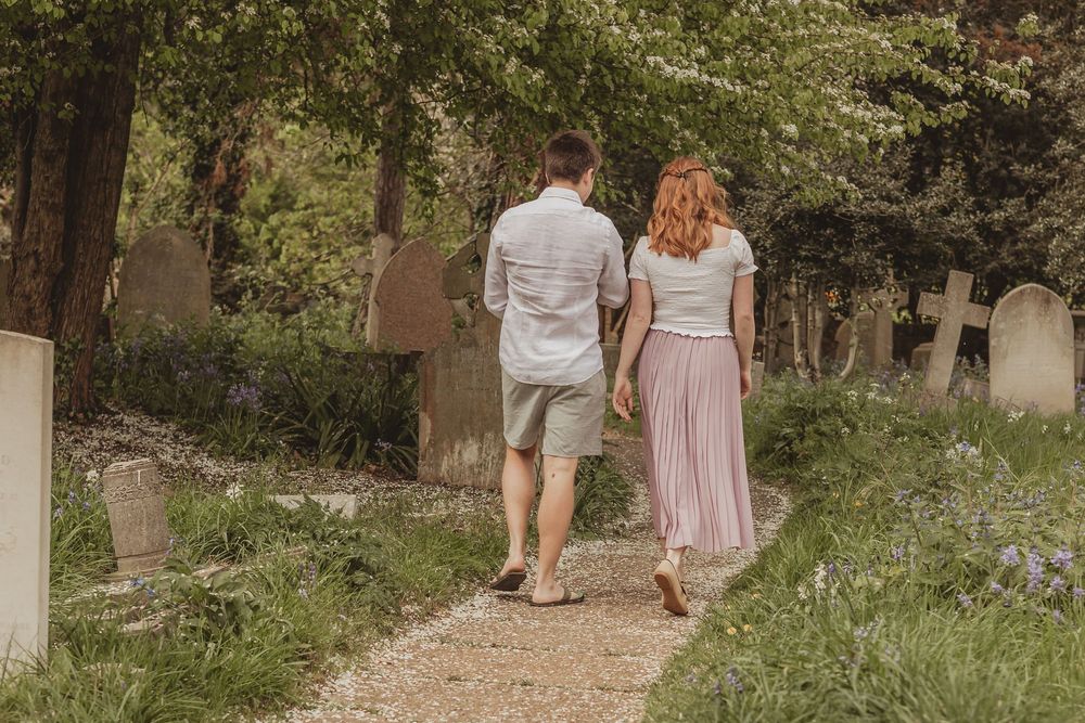 couple walking away from camera in cemetery