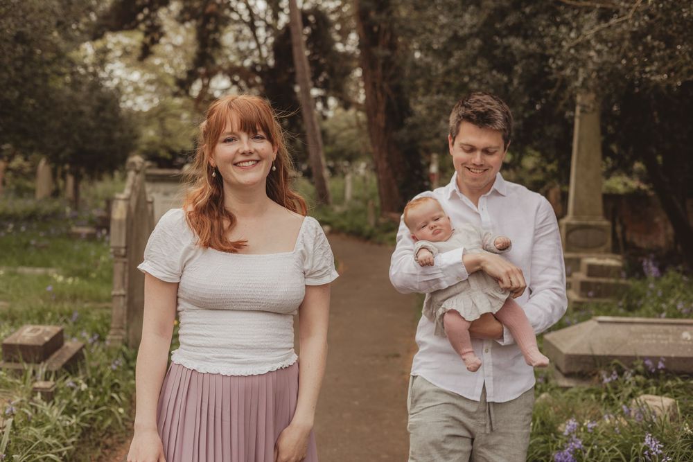 family with baby walking in a churchyard