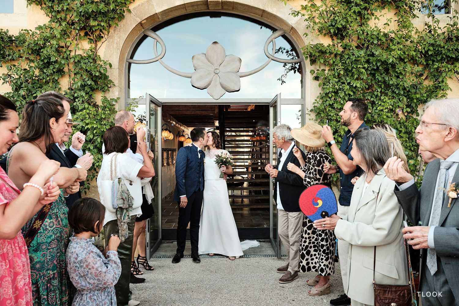TLOOK photographe de mariage de style documentaire, aux portes des iris fin de la cérémonie les mariés s'embrassent