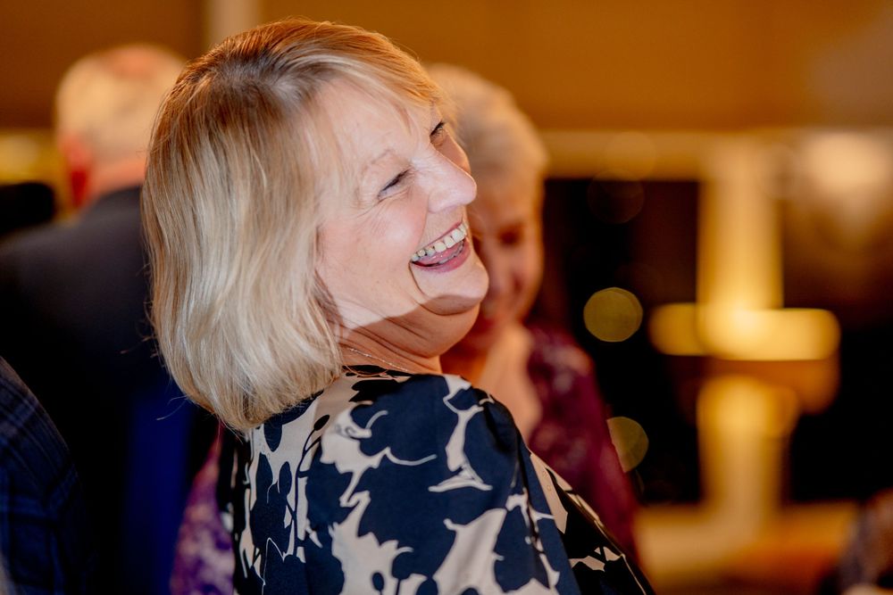 A candid moment of joy and laughter captured at an indoor evening event.