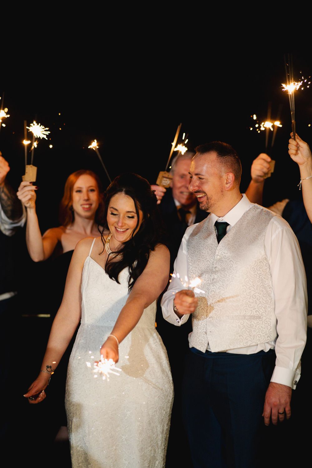 Wedding celebration with sparklers creating a magical nighttime atmosphere.