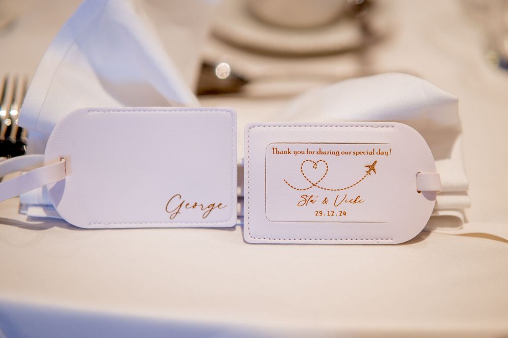 Elegant white wedding place cards with calligraphy and a heart design featuring keys on a table setting.