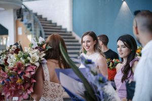 Festive gathering with colorful flower arrangements and smiling attendees.