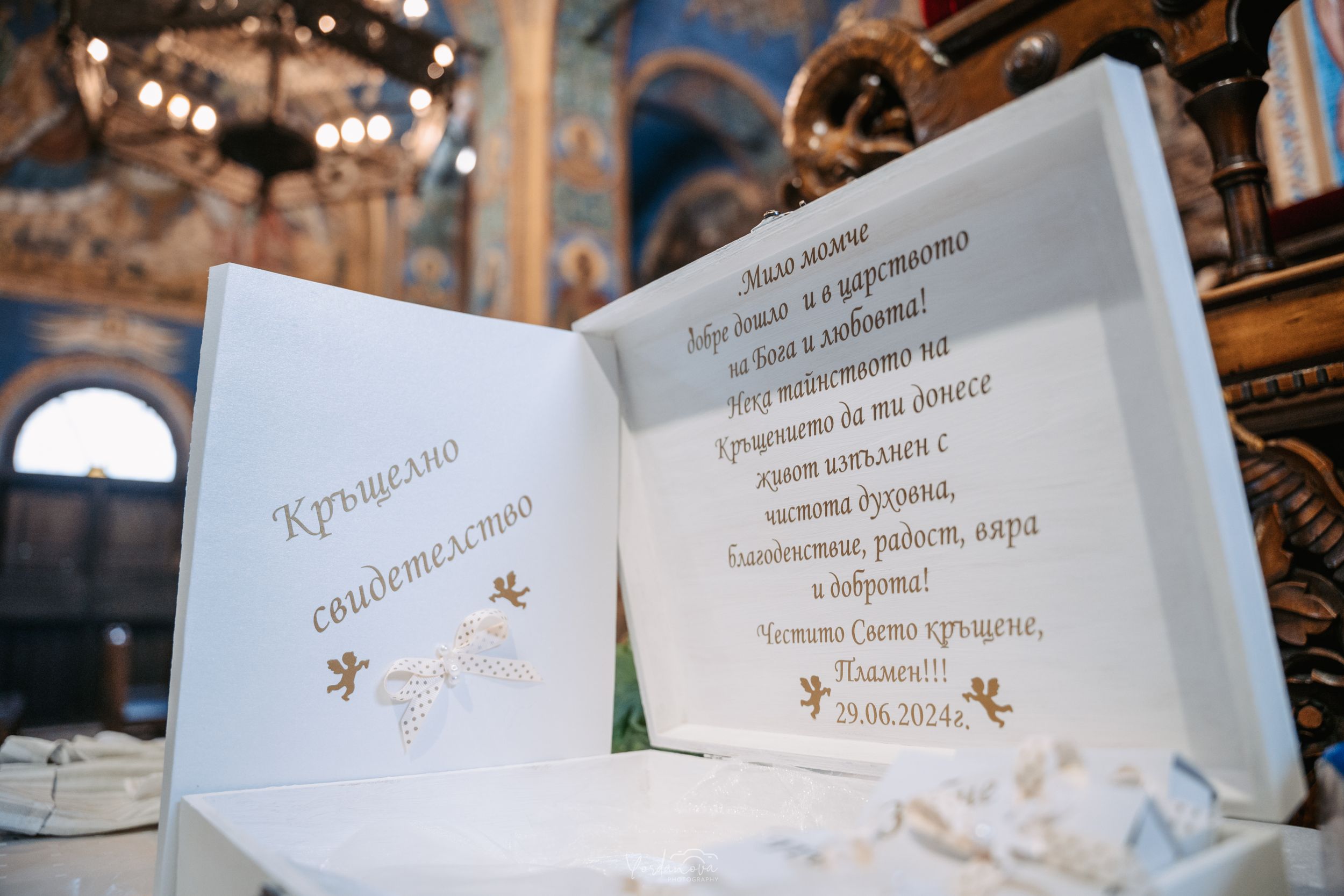 Wedding ceremony program book with gold details lying open on table.