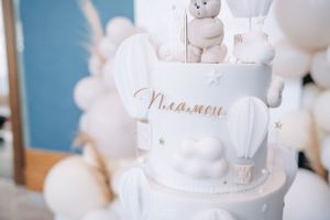 White teddy bear decorations and elegant script text displayed at a celebration.