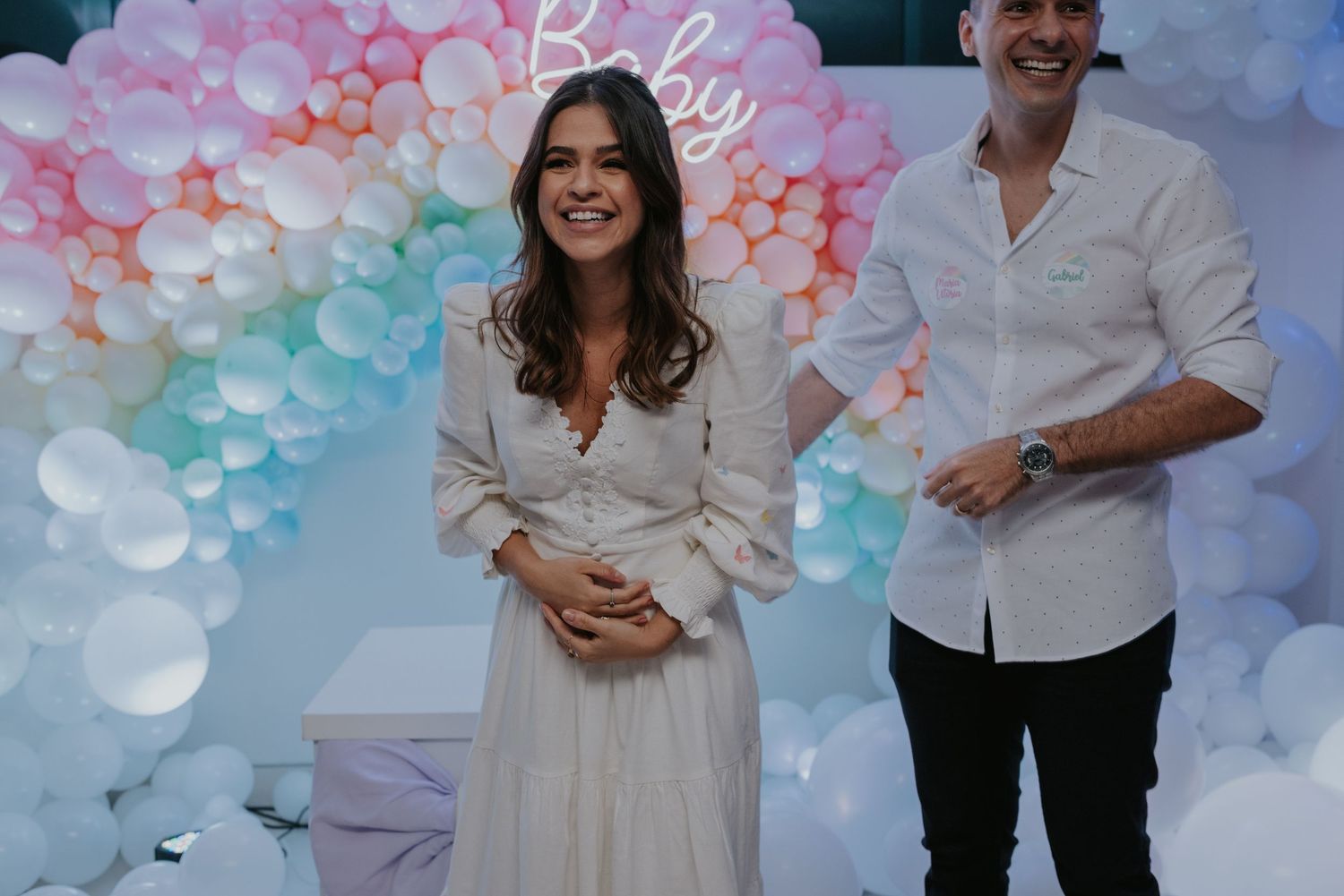 A gender reveal party setup with an elegant balloon arch in pastel pink and blue colors.