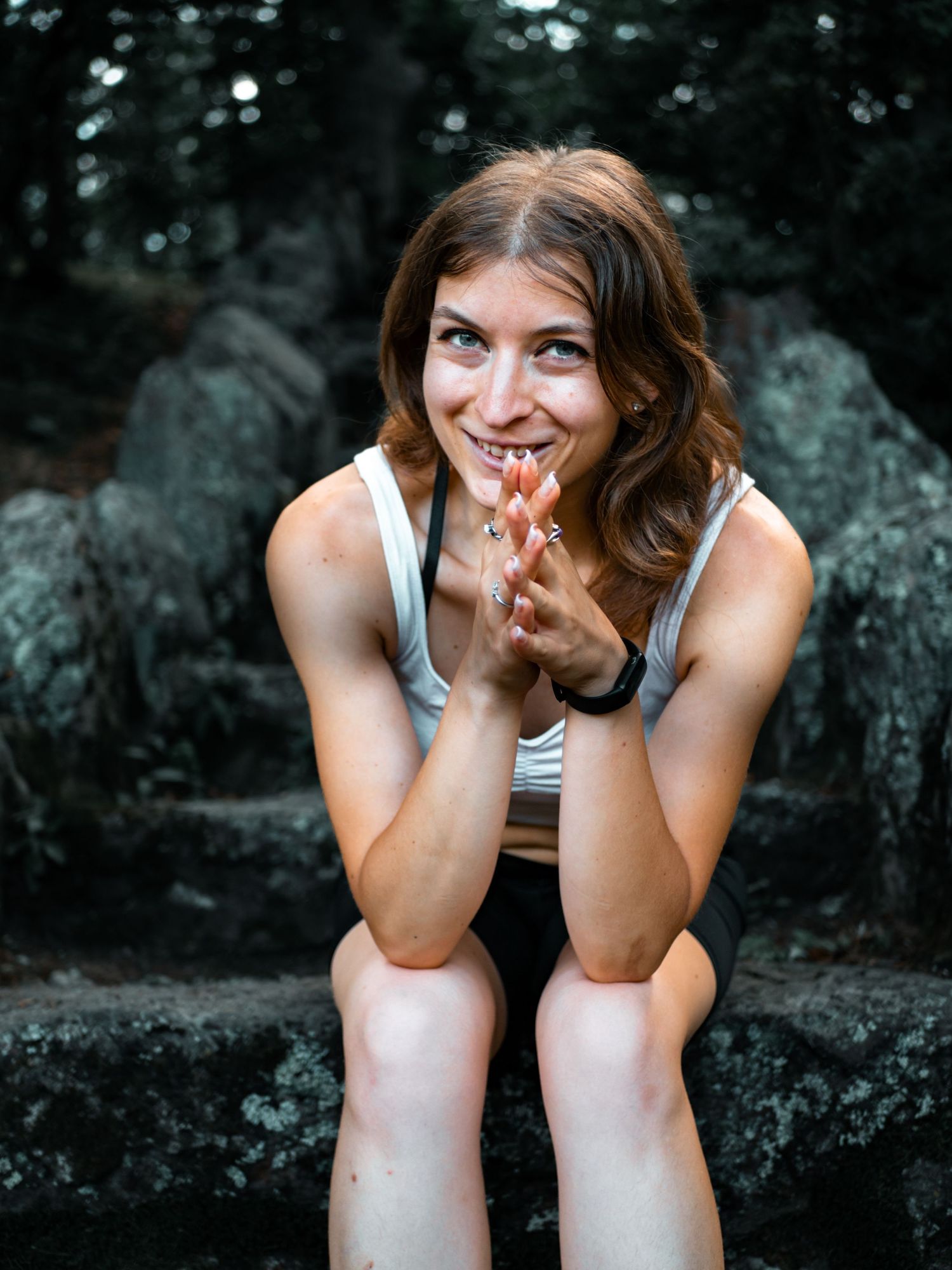 A joyful expression captured in an outdoor portrait against a rocky natural backdrop.