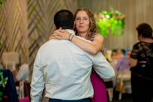 Dance partners moving gracefully across a reception hall floor with ambient lighting.