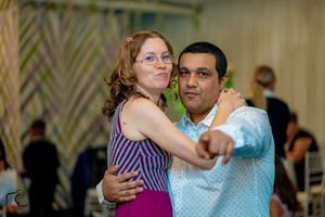 Couple dancing in formal attire at an indoor wedding reception.