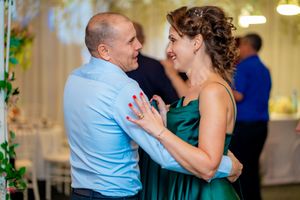 Intimate dance moment captured at an indoor wedding reception with decorative lighting.