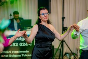 Dancers enjoying a lively party on a dance floor with green and blue lighting effects.