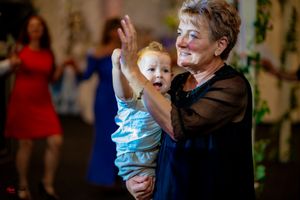 Dancing together at a celebration with festive lighting and decor.