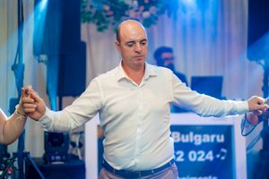 Man in white shirt dancing with arms extended during a celebration.