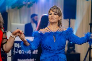 Woman in a royal blue dress dancing gracefully under stage lights.