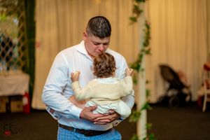 Intimate slow dance moment at an indoor wedding reception with warm lighting.