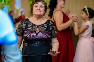 A guest in a black dress watches the festivities at a wedding reception.