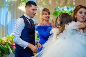 Wedding reception dance scene with elegant decor and floral arrangements.