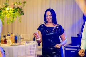 Reception venue decorated with blue uplighting and greenery creates an elegant party atmosphere.