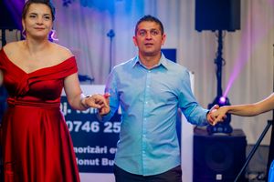 Dancers in formal attire performing at an event with professional lighting setup.