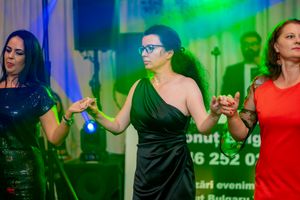 Dancers moving in sequence at an evening event with vibrant lighting effects.