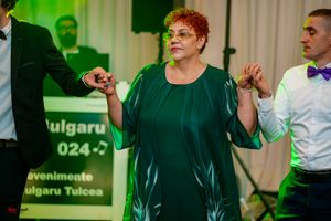 Dancers moving energetically at a formal event with green ambient lighting.