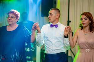 Party guests enjoying themselves on a dance floor with blue and green atmospheric lighting.
