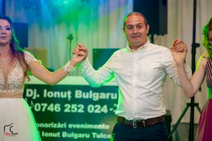 Wedding reception dance floor with DJ booth and contact information displayed on backdrop.