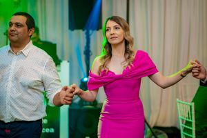 Couples dancing together at an indoor wedding reception with atmospheric lighting.