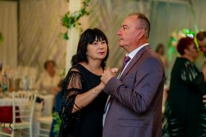 Couples dancing together at an elegant wedding reception with romantic lighting and decor.
