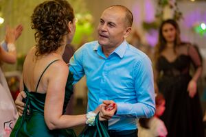 Couples sharing dance moves at a wedding reception with atmospheric lighting effects.