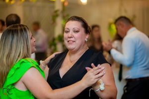 Wedding guests dancing and celebrating on a lively dance floor with colorful lighting.