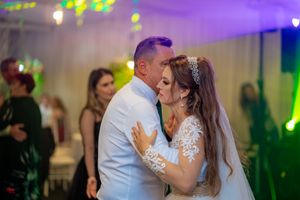 Couples enjoying romantic dances at an elegantly lit indoor reception venue.
