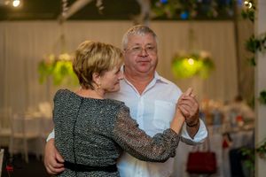 Couples sharing intimate dances at a wedding reception decorated with twinkling lights.