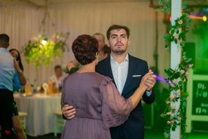 Couples dancing together at an elegant wedding reception with green and purple lighting effects.