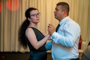 Couples dancing together at a formal indoor wedding reception.