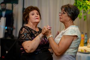 Wedding guests dancing together during an evening reception celebration.