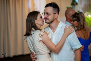 Couples sharing intimate dances at an indoor wedding celebration.