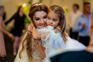 Sweet embrace between a bride and young girl during wedding celebrations.