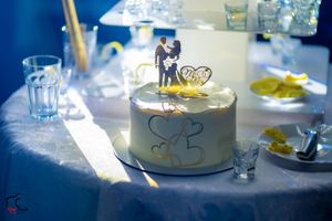 Wedding reception table settings with glassware and plates illuminated by soft lighting at an elegant venue.